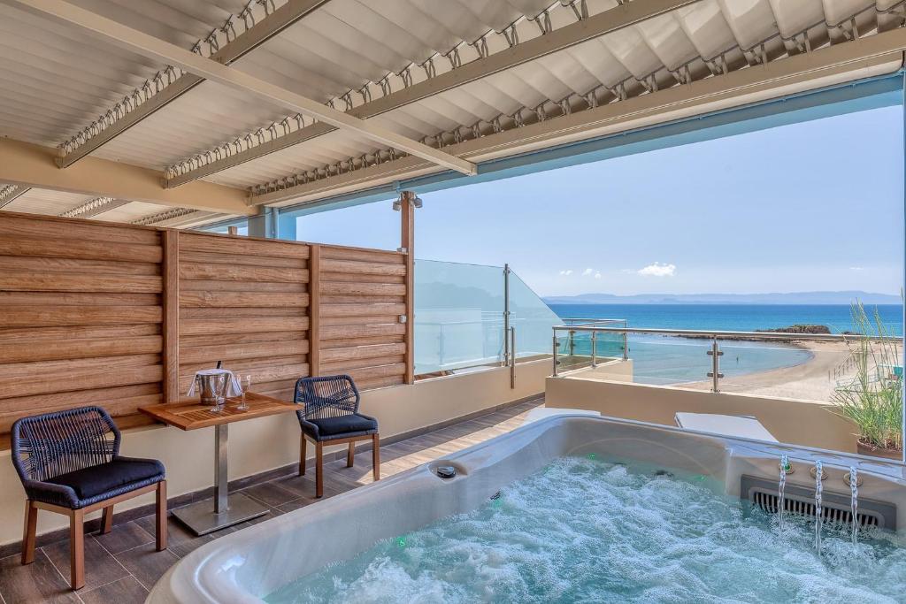 Luksusa jacuzzi ar skatu uz pludmali, kas atrodas terasē, kur ir divas krēsli un galds. Ideāla vieta atpūtai un relaksācijai.