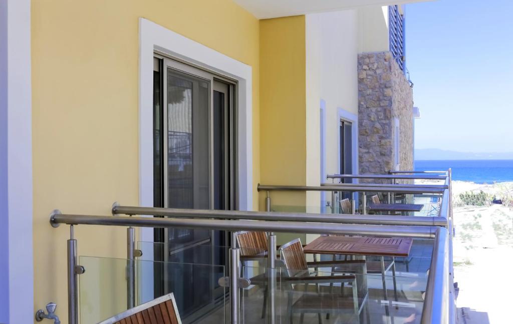 Mūsdienīgs balkons ar koka mēbelēm un skatu uz jūru, izceļot relaksējošu atmosfēru. Ideāli piemērots atpūtai brīvā dabā.