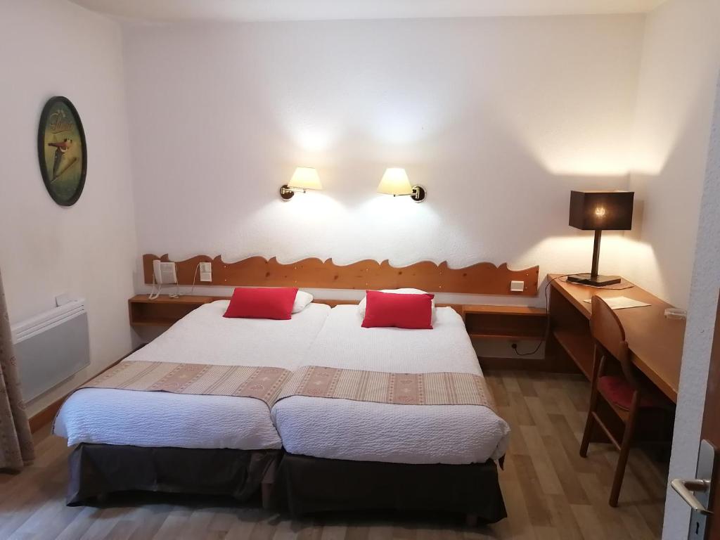 Mūsdienīga viesnīcas istaba ar divām atsevišķām gultām, galdu un krēslu, kā arī apgaismojumu un dekoratīviem elementiem. Siltas krāsas un koka akcenti rada mājīgu atmosfēru.