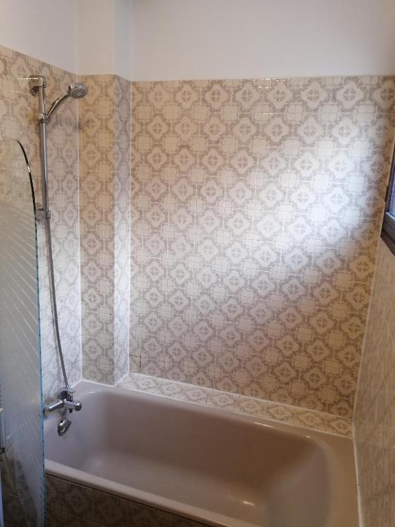 Vannas istaba ar modernu dušas kabīni un flīzēm ar rakstu. Gaisma izgaismo telpu, radot patīkamu atmosfēru.