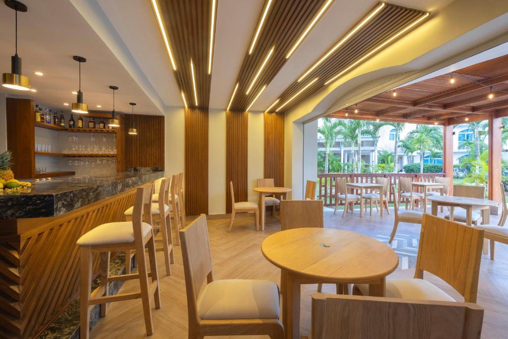 Mūsdienīgs bārs ar koka mēbelēm un apgaismojumu, kas rada patīkamu atmosfēru. Telpa ir plaša un gaiša, ar piekļuvi ārējai terasei.