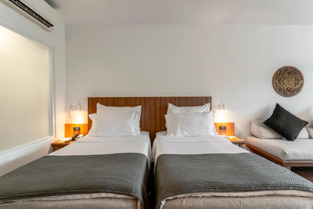 Mūsdienīgs viesnīcas numurs ar divām gultām, elegantu interjeru un atpūtas zonu. Gaismas un neitrālas krāsas radījušas patīkamu atmosfēru.