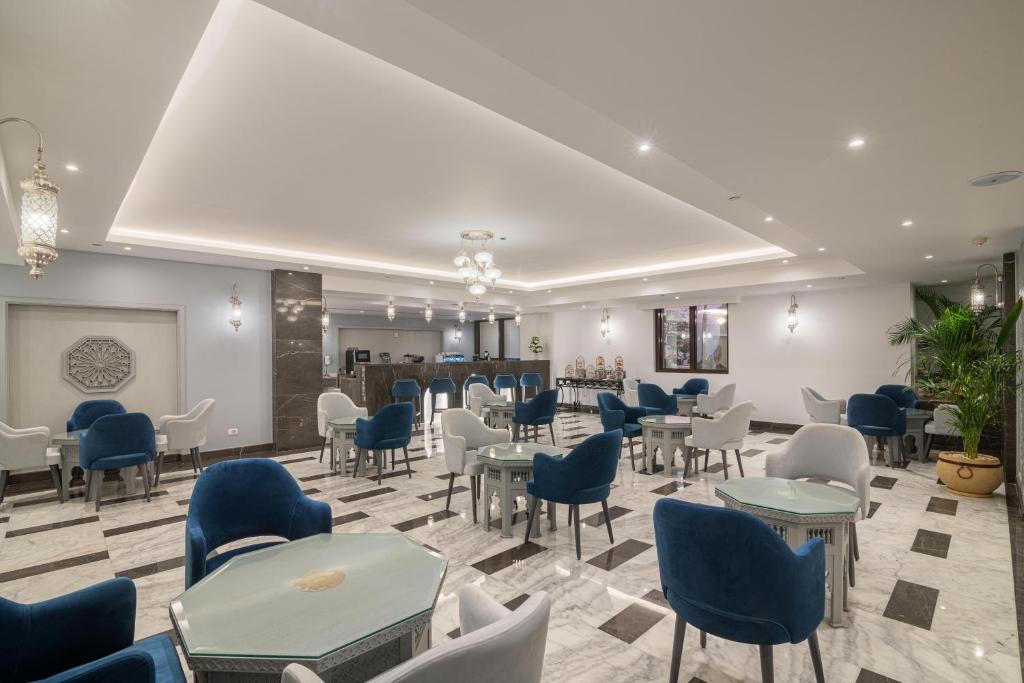 Elegants restorāns ar mīkstiem zila un pelēka krāsas krēsliem, marmora grīdu un mūsdienīgu apgaismojumu, radot patīkamu atmosfēru. Ideāla vieta relaksācijai un socializēšanai.