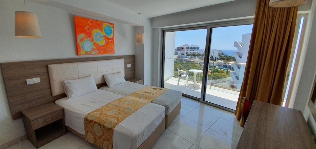 Moderns viesnīcas numurs ar divām gultām, panorāmas logiem un skatu uz jūru, dekorēts ar krāsainu mākslas darbu. Gaismas un gaišas krāsas rada patīkamu atmosfēru.