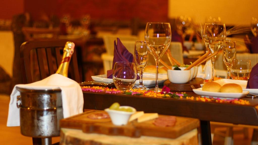 Eleganti izkārtots galds ar šampanieti, glāzēm un gardām uzkodām, radot romantisku atmosfēru. Galds rotāts ar ziedlapiņām un smalkām detaļām.