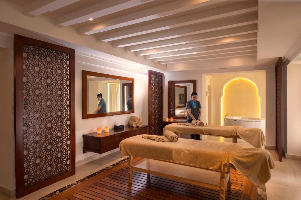 Relaksējoša spa telpa ar masāžas galdiem un apgaismojumu, kas rada mierīgu atmosfēru. Piemērota vide atpūtai un labsajūtai.