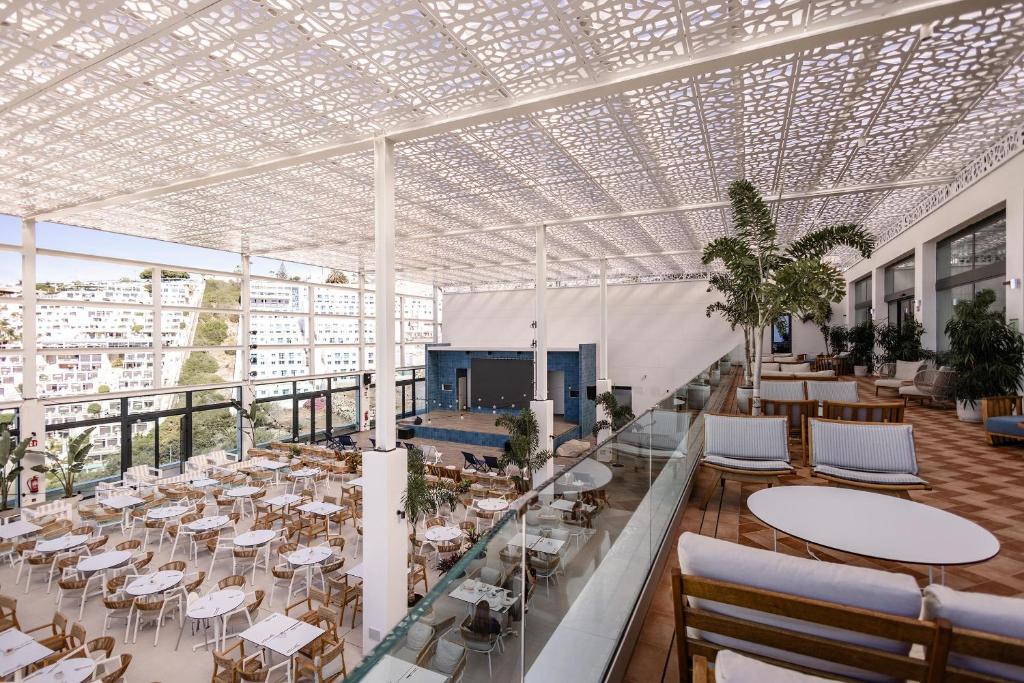 Moderns restorāns ar plašu terasi, dekorēts ar zaļām augiem un elegantiem galdiem. Gaisīga un atvērta atmosfēra, kas nodrošina lielisku skatu uz apkārtni.