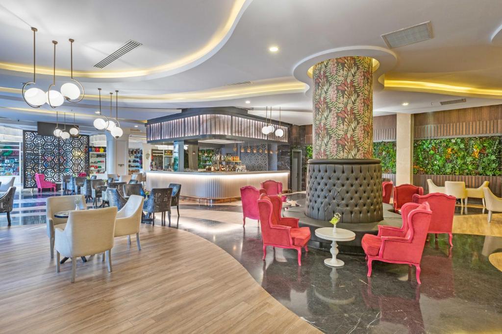 Mūsdienīgs viesnīcas bārs ar elegantām krēslām un stilīgu apgaismojumu, kas rada aicinošu atmosfēru. Interjers apvieno dabu un moderno dizainu.