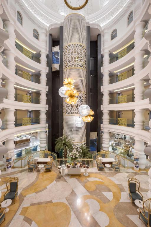 Greznas viesnīcas vestibuls ar elegantu dizainu, iespaidīgu gaismekļu un augu klātbūtni. Interjers apvieno mūsdienīgas un tradicionālas arhitektūras elementus ar plašu telpu un gaismu.
