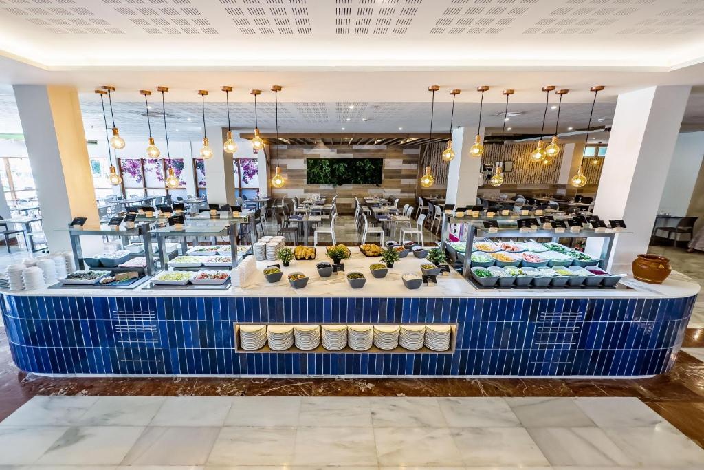 Mūsdienīgs restorāns ar plašu bufeti, kurā ir dažādi ēdieni un dekoratīvi elementi. Interjers ir gaišs un atsvaidzinošs, ar elegantiem apgaismojuma risinājumiem.