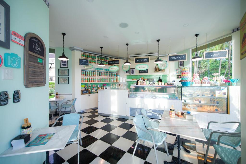 Kafejnīca ar gaišām krāsām un šarmantu interjeru, kurā redzama saldējuma un kūku vitrīna, kā arī komfortabli galdi un krēsli. Ideāla vieta, lai izbaudītu saldumus un relaksējošu atmosfēru.