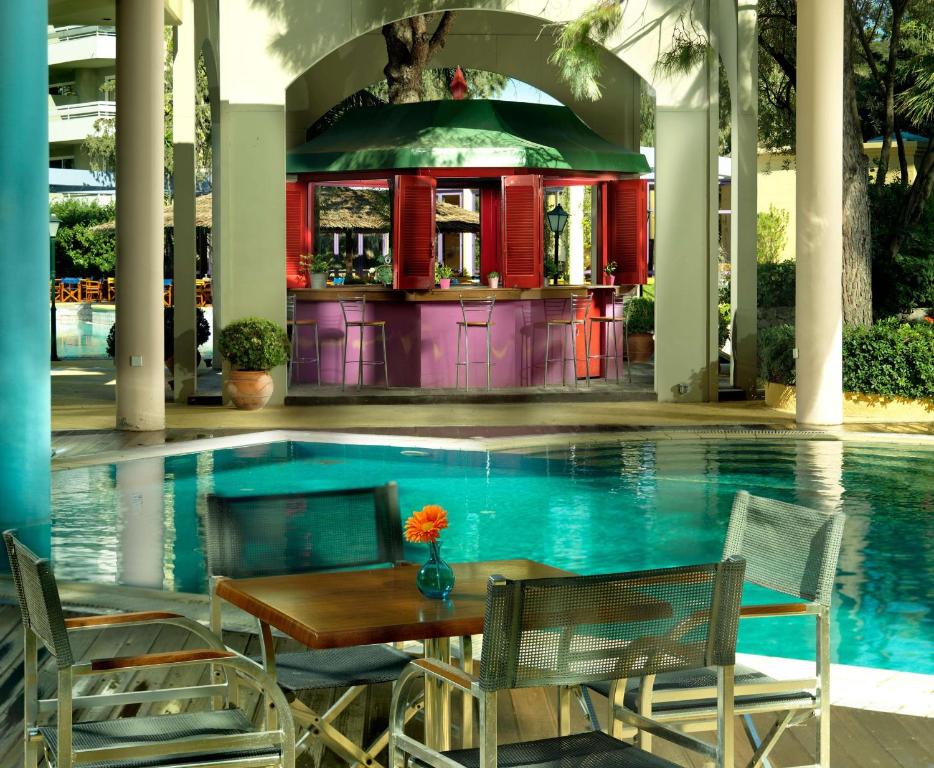 Baseina zona ar bāru un mēbelēm, kas izvietotas pie ūdens. Šī gleznainā vide ir ideāla relaksācijai un atpūtai.