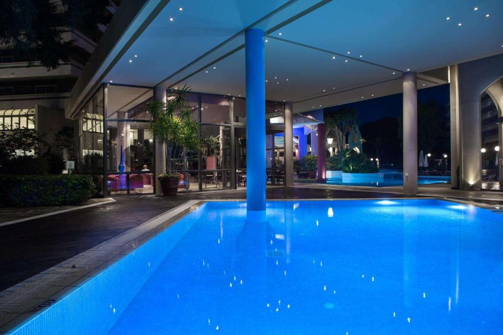 Mūsdienīgs naktsklubs ar baseinu, kas izgaismots ar zilu gaismu, un stikla sienām, caur kurām redzams iekštelpu dārzs. Baseins ir apņemts ar elegantiem mēbeļiem un zaļumiem, radot relaksējošu atmosfēru.