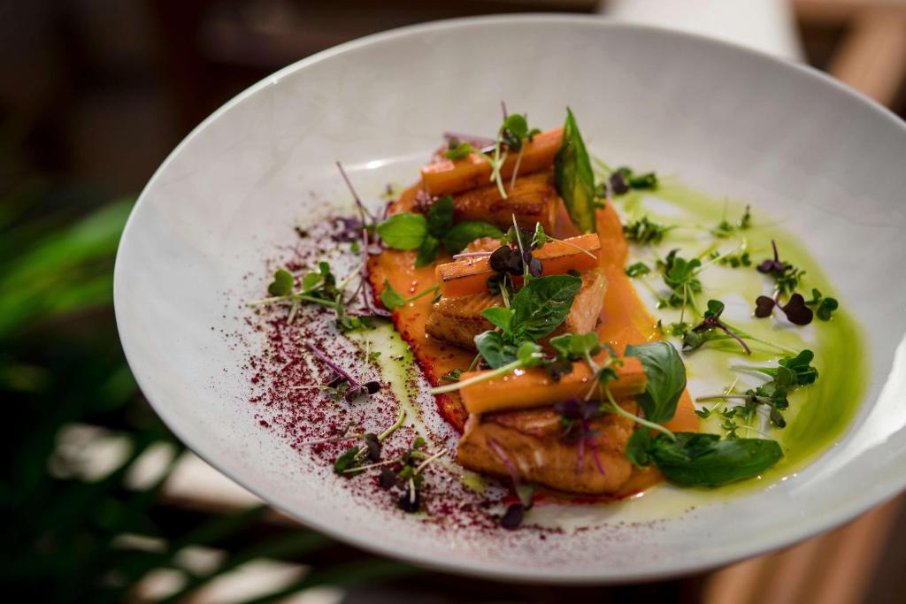 Gurķu salāti ar ceptu vistas gaļu, apstrādāti ar zaļo mērci un dekorēti ar svaigiem garšaugiem. Elegants un krāsains pasniegšanas veids, kas uzsver kulinārijas mākslu.