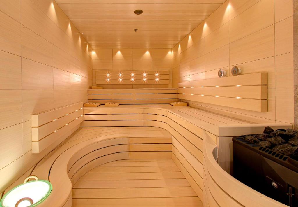 Mūsdienīga sauna ar koka apdari, maigu apgaismojumu un komfortablām sēdvietām, radot relaksējošu atmosfēru. Ideāla vieta atpūtai un atjaunošanai.