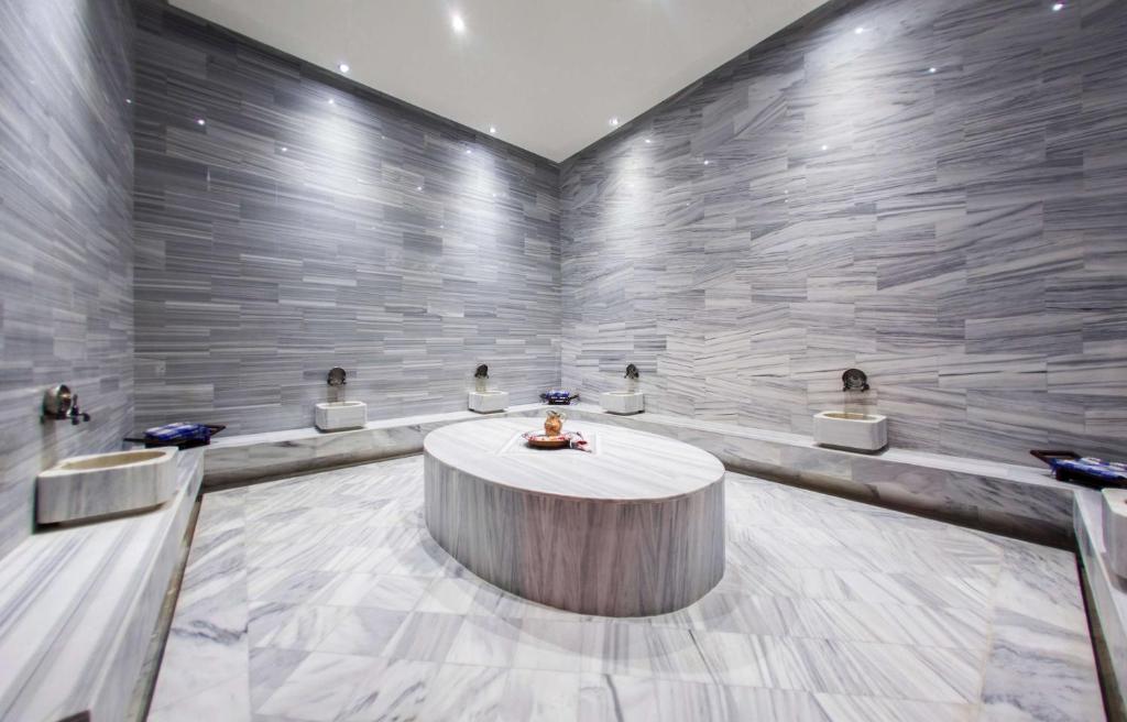 Moderns un elegants marmora dizaina vannas istaba ar apgaismojumu un vairākām mazgāšanās vietām. Piemērots relaksācijai un komfortam.