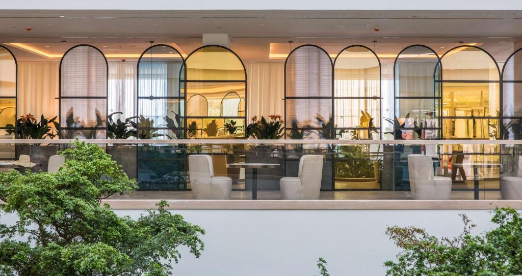 Moderns interjers ar lieliem logiem un augu kompozīcijām, kas rada mierīgu atmosfēru. Eleganti krēsli un gaišas krāsas papildina telpas estētiku.