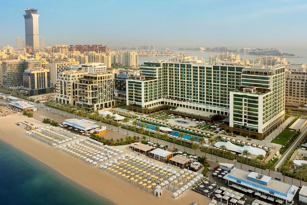 Mūsdienīga piejūras viesnīca Dubaijā ar skaistu pludmali, baseinu un luksusa ēkām, kas piedāvā lielisku skatu uz pilsētu un jūru.