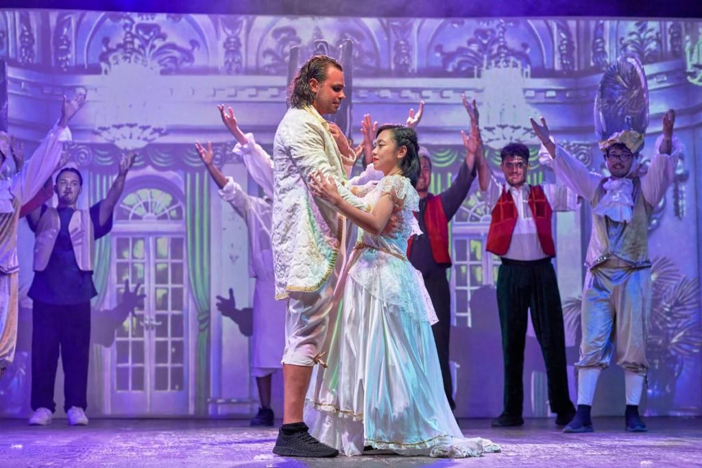 Teātra izrāde ar dejotājiem elegantos kostīmos.