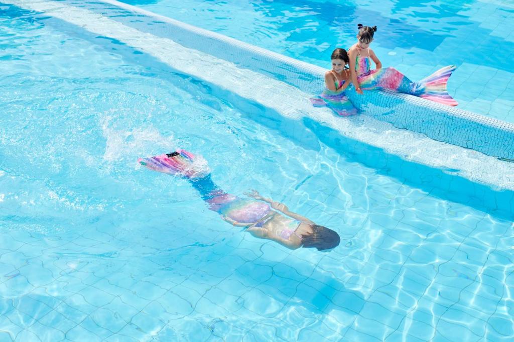 Bērni baseinā ar nāriņu kostīmiem Serene Resort