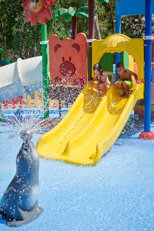 Bērni rotaļu laukumā ar ūdens slidkalniņu Serene Resort.