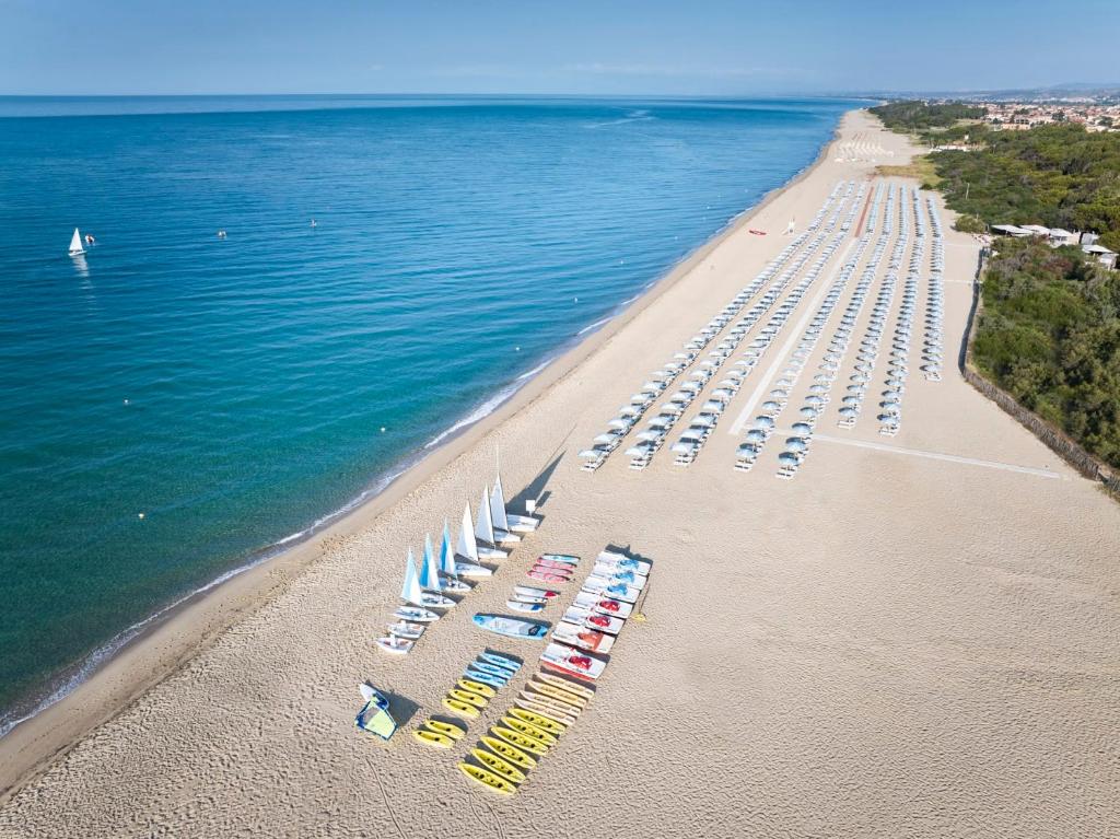 Serene Resort pludmale ar baltiem saulessargiem un laivām.