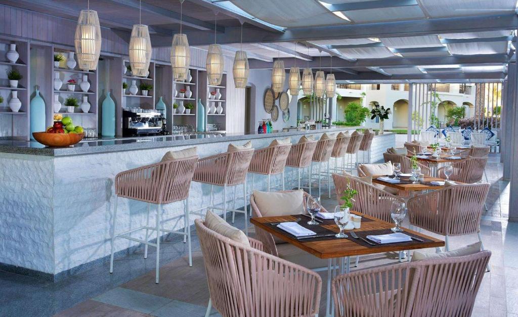 Mūsdienīgs restorāns ar elegantu interjeru, kas ietver stilīgas mēbeles un apgaismojumu, radot relaksējošu atmosfēru. Bārs ar plašu dzērienu izvēli un galdiņi, kuriem uzklāti galda piederumi.