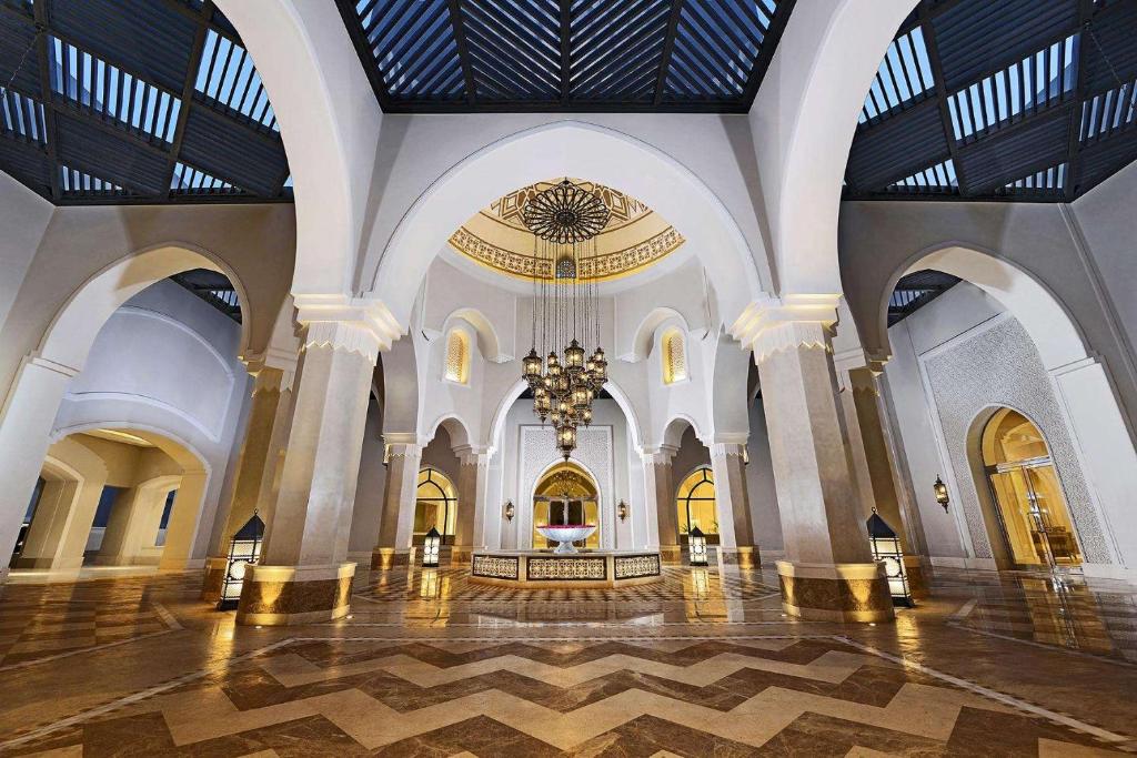Greznā interjera dizaina piemērs ar arku un izsmalcinātu apgaismojumu, kas rada elegantu atmosfēru. Šis telpas skats atklāj dekoratīvos elementus un plašumu.