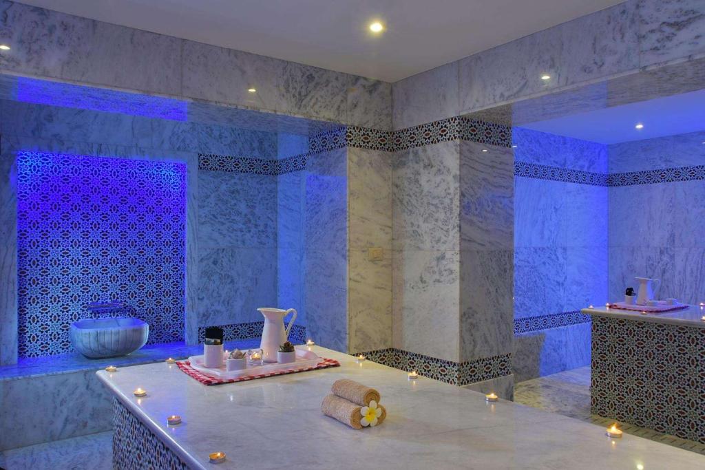 Mūsdienīgs spa ar marmora sienām, dekoratīviem elementiem un relaksējošu apgaismojumu, radot mierīgu un atpūtu veicinošu atmosfēru.