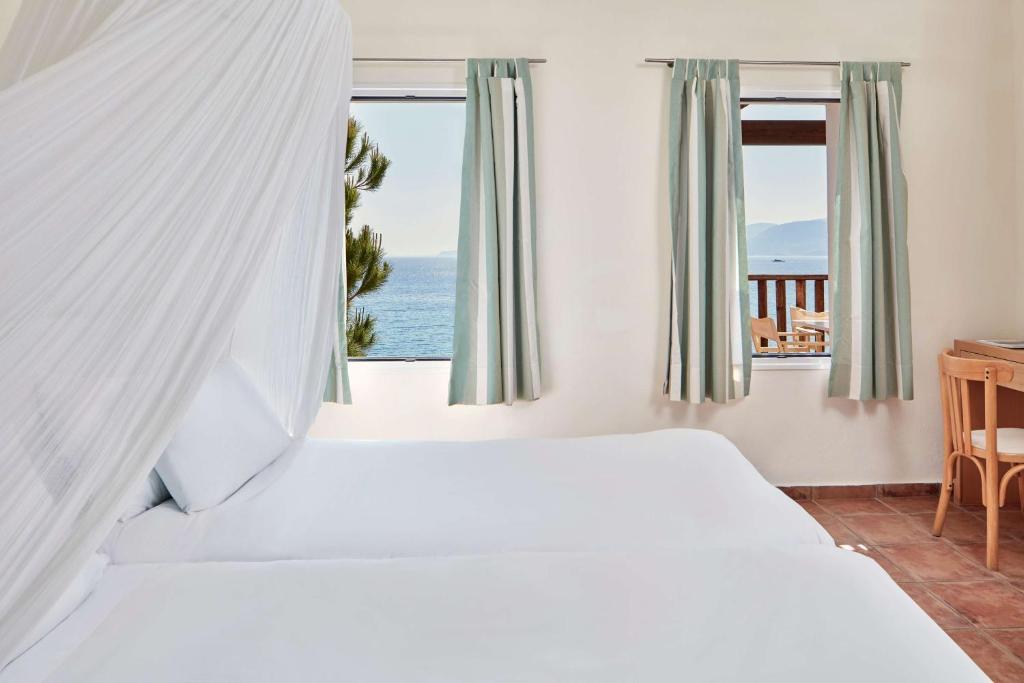 Gaisma un moderns viesnīcas numurs ar divām atsevišķām gultām un skatu uz jūru caur logiem. Interjērs ir vienkāršs un elegants, ar gaišām krāsām un mūsdienīgu mēbeļu elementiem.