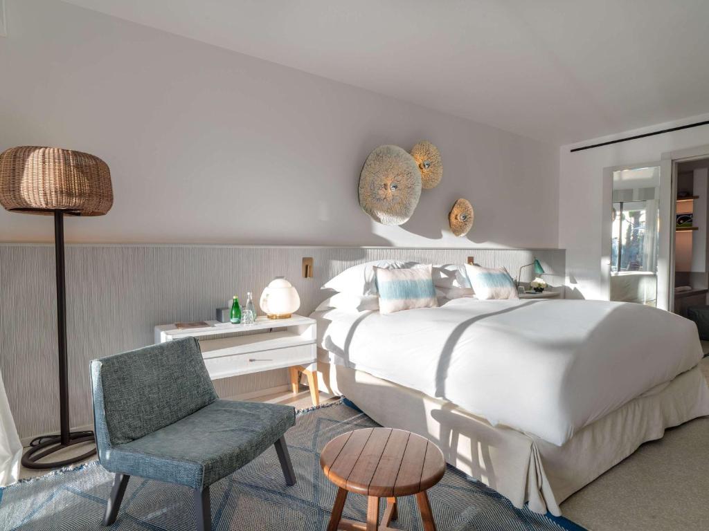 Mūsdienīgs guļamistabas interjers ar ērtu gultu un dekoratīvām sienu rotājumiem, papildināts ar stilīgu mēbeļu komplektu. Svaiga un gaiša atmosfēra, kas veicina relaksāciju un komfortu.