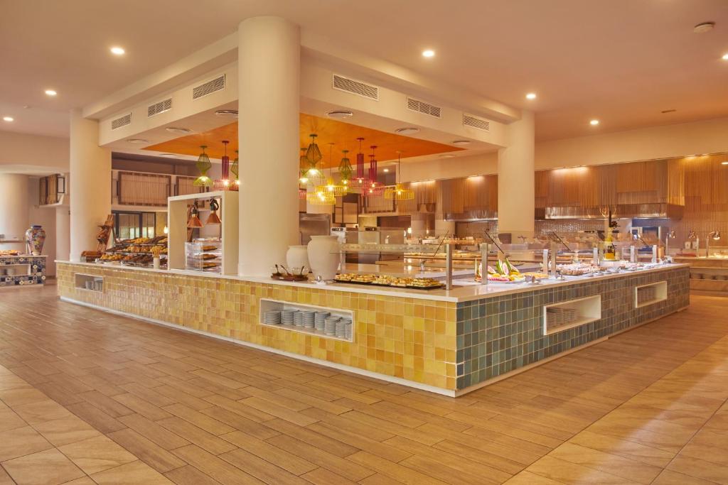 Moderns viesnīcas bufetes restorāns ar plašu ēdienu izvēli un stilīgu interjeru. Gaismas elementi un krāsainas flīzes piešķir telpai siltumu un viesmīlību.