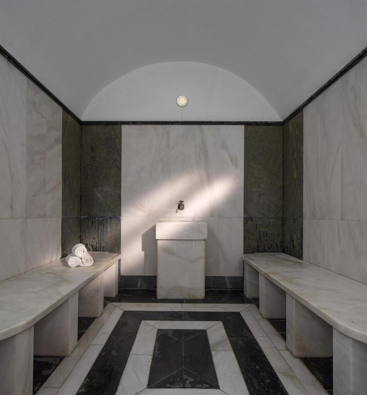 Marmora interjers ar divām soliem un ūdens strūklaku centrā, radot mierīgu atmosfēru. Gaisma plūst caur telpu, uzsverot mūsdienīgo dizainu.