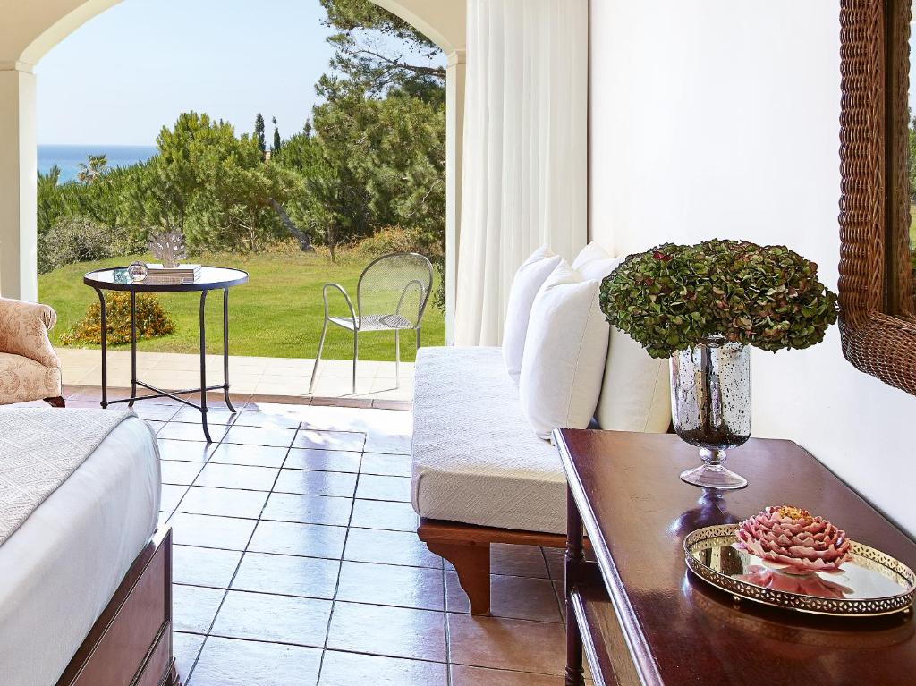 Moderns viesnīcas numurs ar gleznainu skatu uz dārzu un jūru, iekārtots ar elegantu mēbelēm un dekoratīvām puķēm. Ideāla vieta atpūtai un relaksācijai.