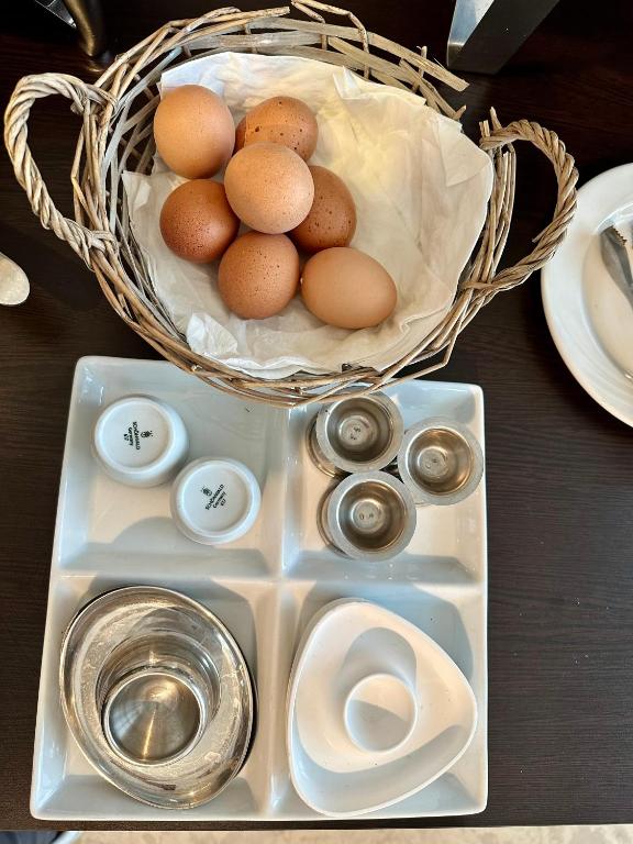 Baskā ar astoņām olām un papildu traukiem, kas paredzēti pārtikas pasniegšanai, piemēram, sāls un piparu traukiem.