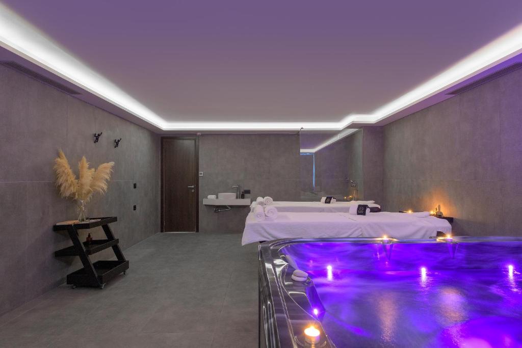 Mūsdienīgs spa interjers ar relaksējošu burbuļvannu un masāžas galdiem, izgaismots ar siltu apgaismojumu. Šī telpa ir ideāla atpūtai un labsajūtai.