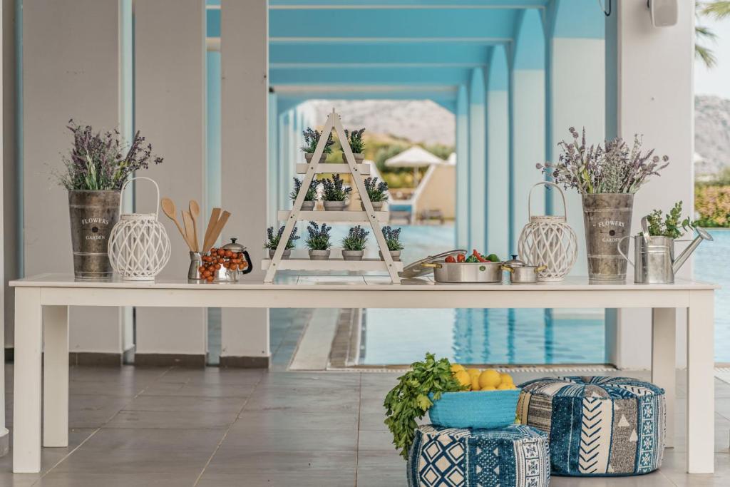 Galda dekorācija pie baseina ar ziedu kompozīcijām, virtuves piederumiem un augļiem. Mūsdienīgs dizains ar zilu krāsu akcentiem, radot relaksējošu atmosfēru.