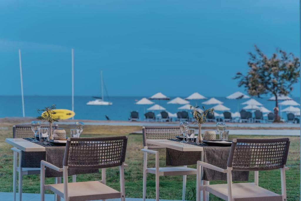 Pludmales restorāna terase ar galdiem un krēsliem, skats uz jūru un sauļošanās krēsliem. Ideāla vieta relaksācijai un maltītei.