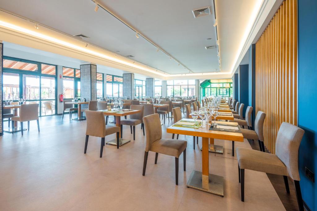 Mūsdienīgs restorāns ar elegantiem galdiem un krēsliem, kas nodrošina plašu skatu uz ārpusi. Interjers ir gaišs un atvērts, radot patīkamu atmosfēru.