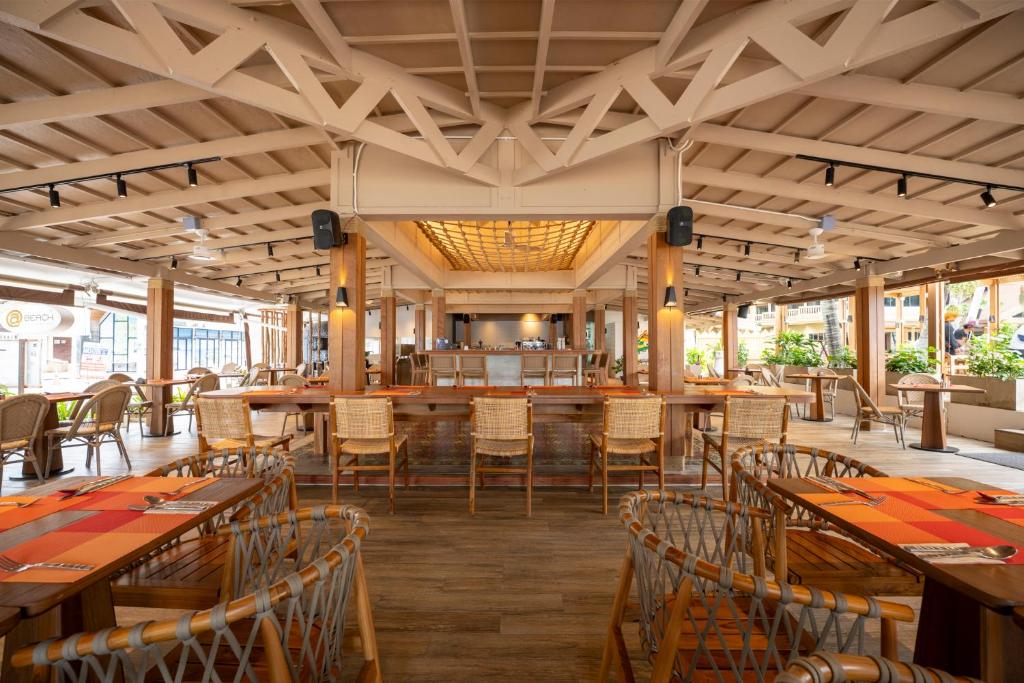 Mūsdienīgs restorāna interjers ar koka struktūru un ērtām sēdvietām, kas nodrošina patīkamu atmosfēru. Gaisma un augu klātbūtne piešķir telpai svaigumu un unikalitāti.