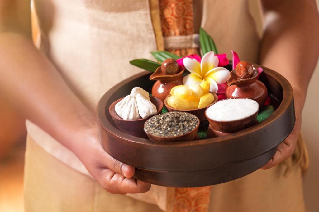 Tradicionāla masāžas trauka ar dabīgām sastāvdaļām, ko tur rokās, ieskaitot garšvielas un ziedus. Ideāli piemērots spa vai relaksācijas sesijām.