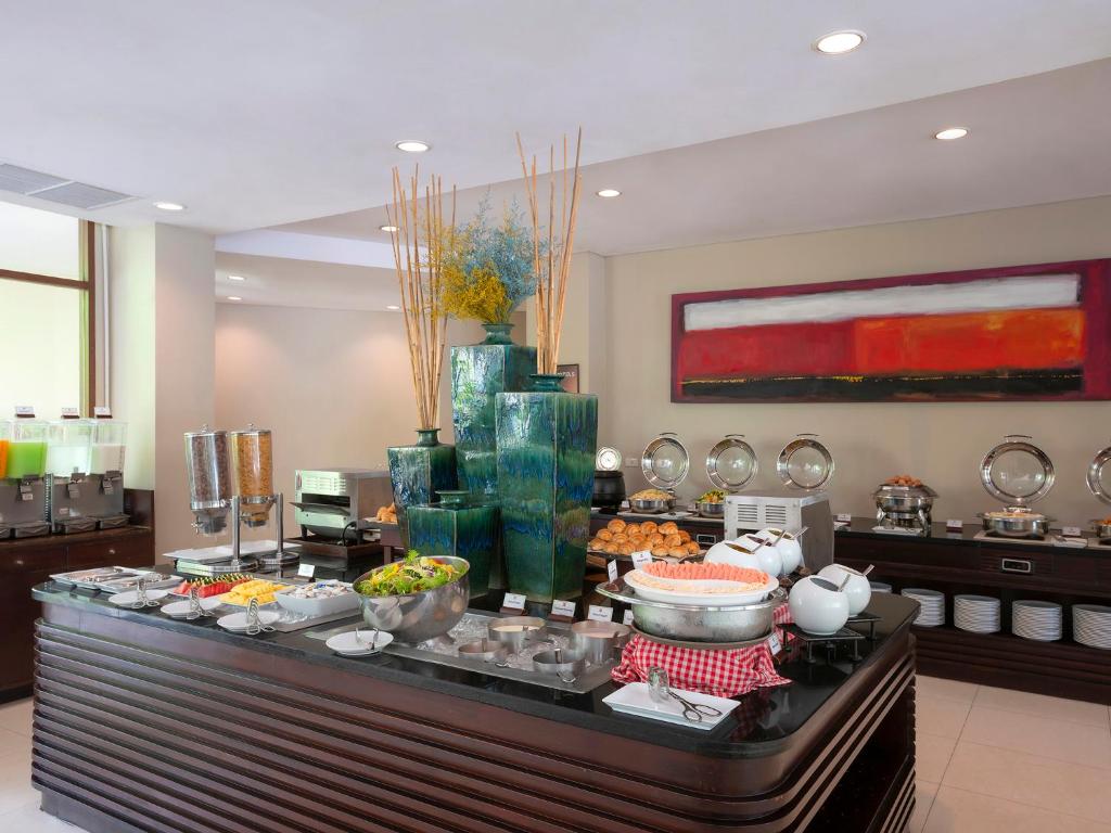 Labi iekārtota bufete ar dažādiem ēdieniem, salātiem un dzērieniem, akcentēta ar dekoratīviem elementiem un modernām krāsām.