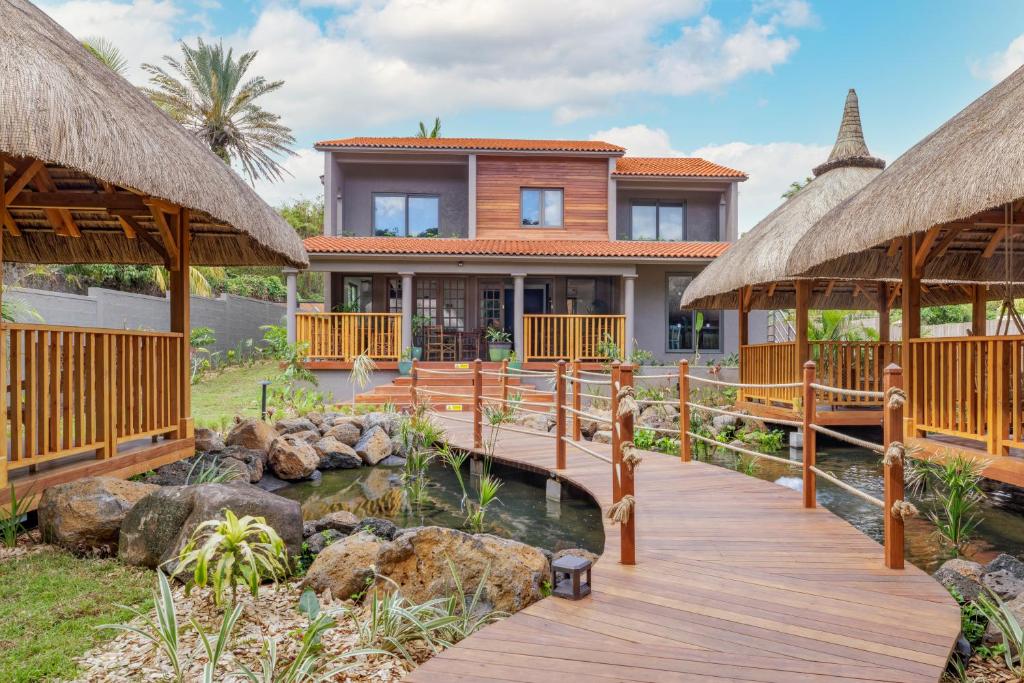 Mūsdienīga māja ar koka tiltu un tradicionāliem jumtiem, kas savienojas ar dārzu un ūdenstilpni. Ideāla vieta atpūtai un relaksācijai.