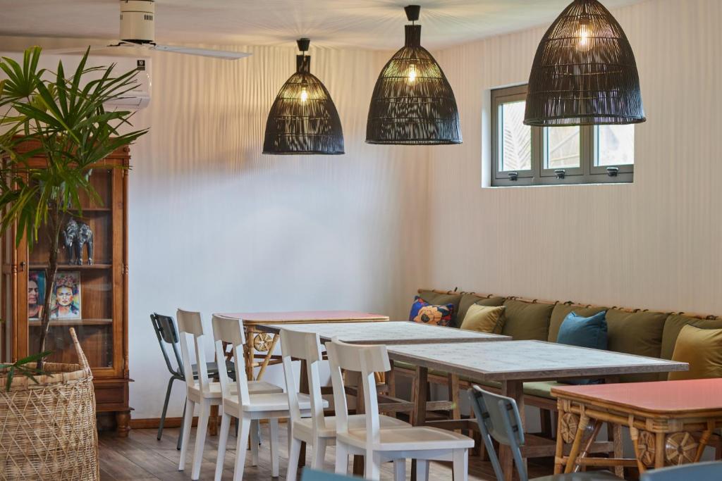 Mūsdienīgs un stilīgs interjers ar koka galdiem, baltām krēslām un melnām lampām. Telpā ir atpūtas zona ar dīvāniem un dekoratīvām spilveniem.