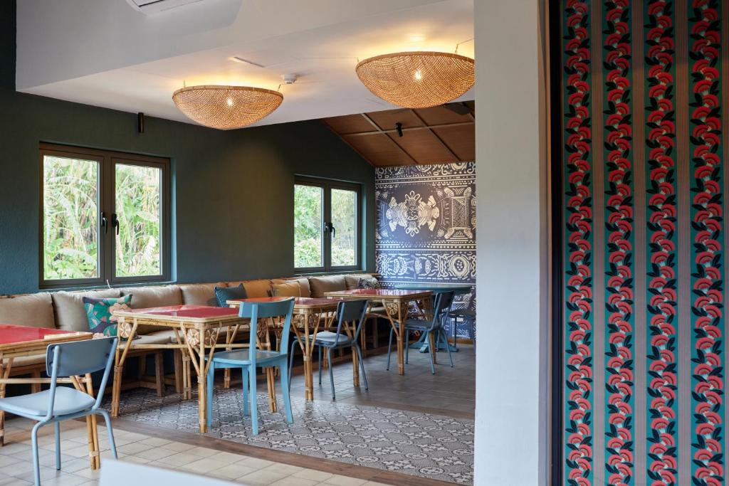Mūsdienīgs interjers ar ērtām sēdvietām un dekoratīvām lampām, kas rada patīkamu atmosfēru. Sienas rotā krāsaini raksti un logi piedāvā skatu uz dabu.