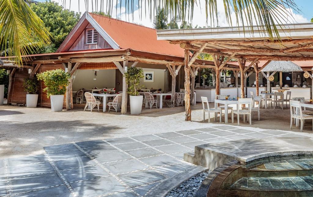 Skaista ārējā ēdamzāle ar koka konstrukcijām un zāles apstādījumiem, ideāla atpūtai un maltītēm brīvā dabā. Apkārt ir gaišas galdi un krēsli, radot relaksējošu atmosfēru.