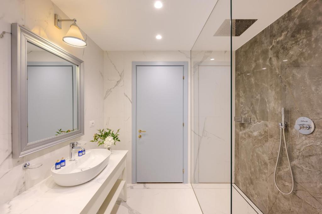 Moderns vannas istabas interjers ar elegantu akmens apdari, mūsdienīgu izlietni un spoguli. Gaismas un telpas harmonija rada patīkamu atmosfēru.