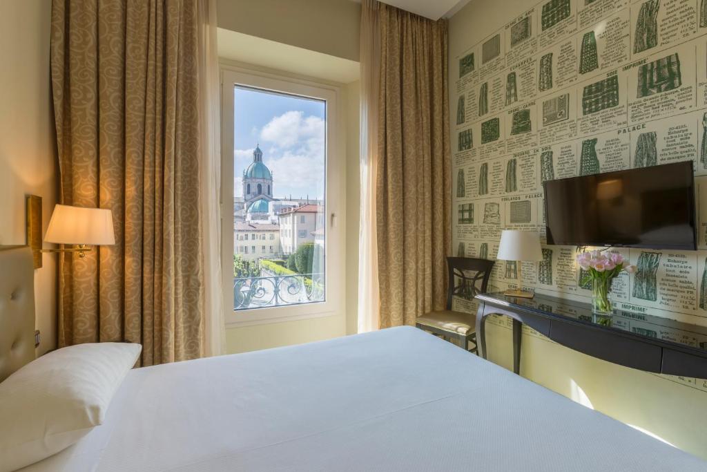 Mūsdienīgs viesnīcas numurs ar skatu uz pilsētas ainavu, kas ietver vēsturisku kupolu un stilīgu interjeru ar dekoratīvu sienu.