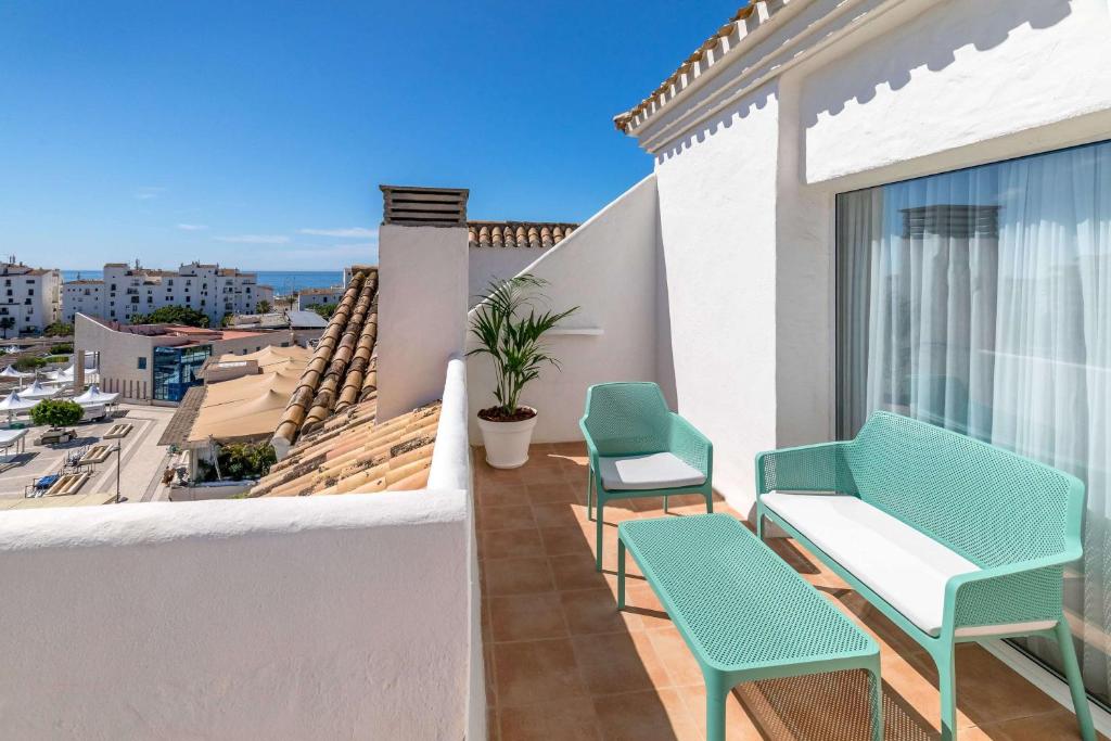 Skaista terase ar skatu uz jūru, kurā ir moderni mēbeļu komplekti un zaļa auga podi. Ideāla vieta atpūtai un relaksācijai.