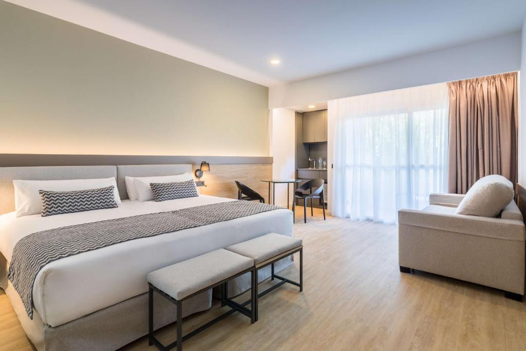 Moderns viesnīcas numurs ar divguļamo gultu, komfortablu dīvānu un nelielu galdu. Gaisīgs un gaišs interjers ar lieliem logiem, kas nodrošina dabisko apgaismojumu.